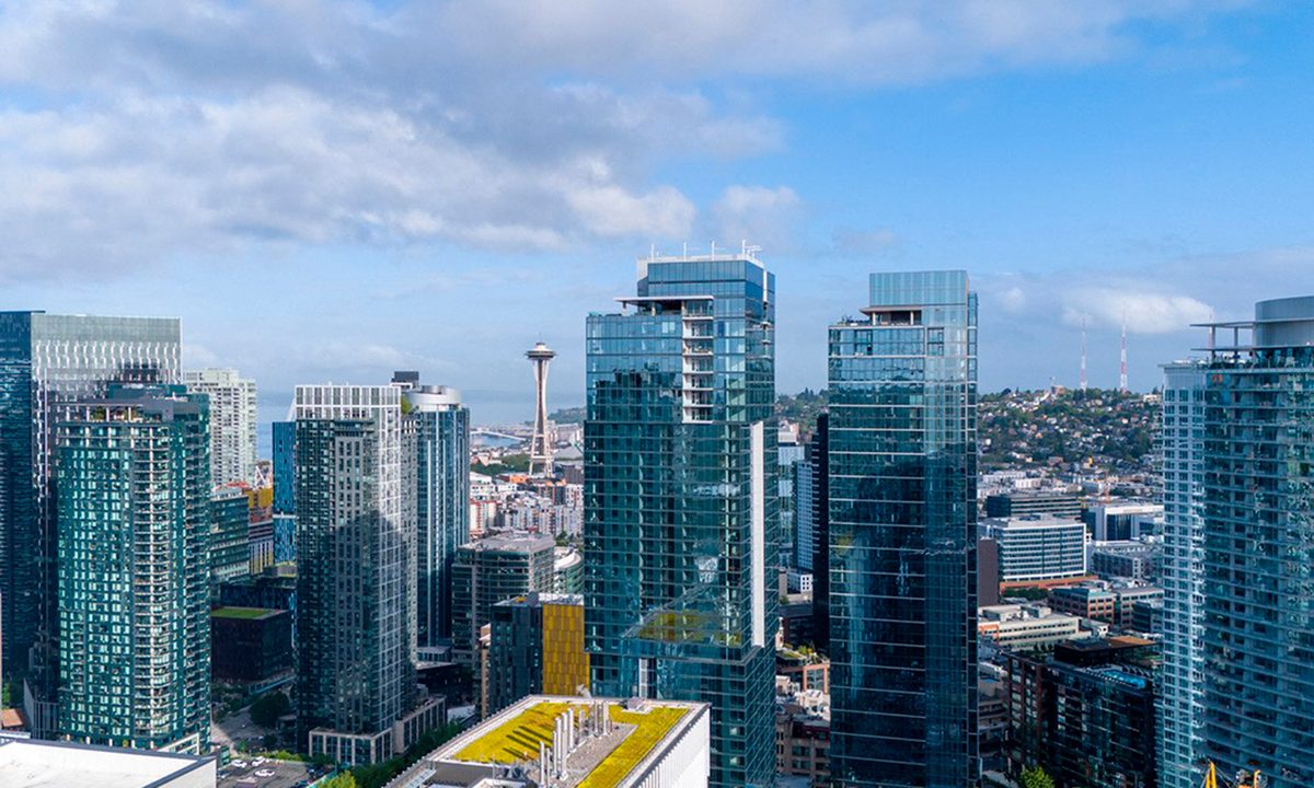 The Ayer rises among Seattle's Denny Triangle towers, illustrating the 46-story multifamily property acquired by BentallGreenOak for $353 million.