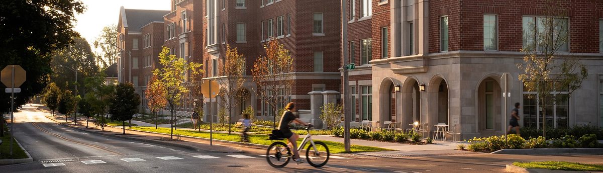 A streetscape rendering of The Beverly in Bloomington shows the six-story brick and Indiana limestone student housing community celebrated by Buckingham Companies and Indiana University at its 2026 grand opening.