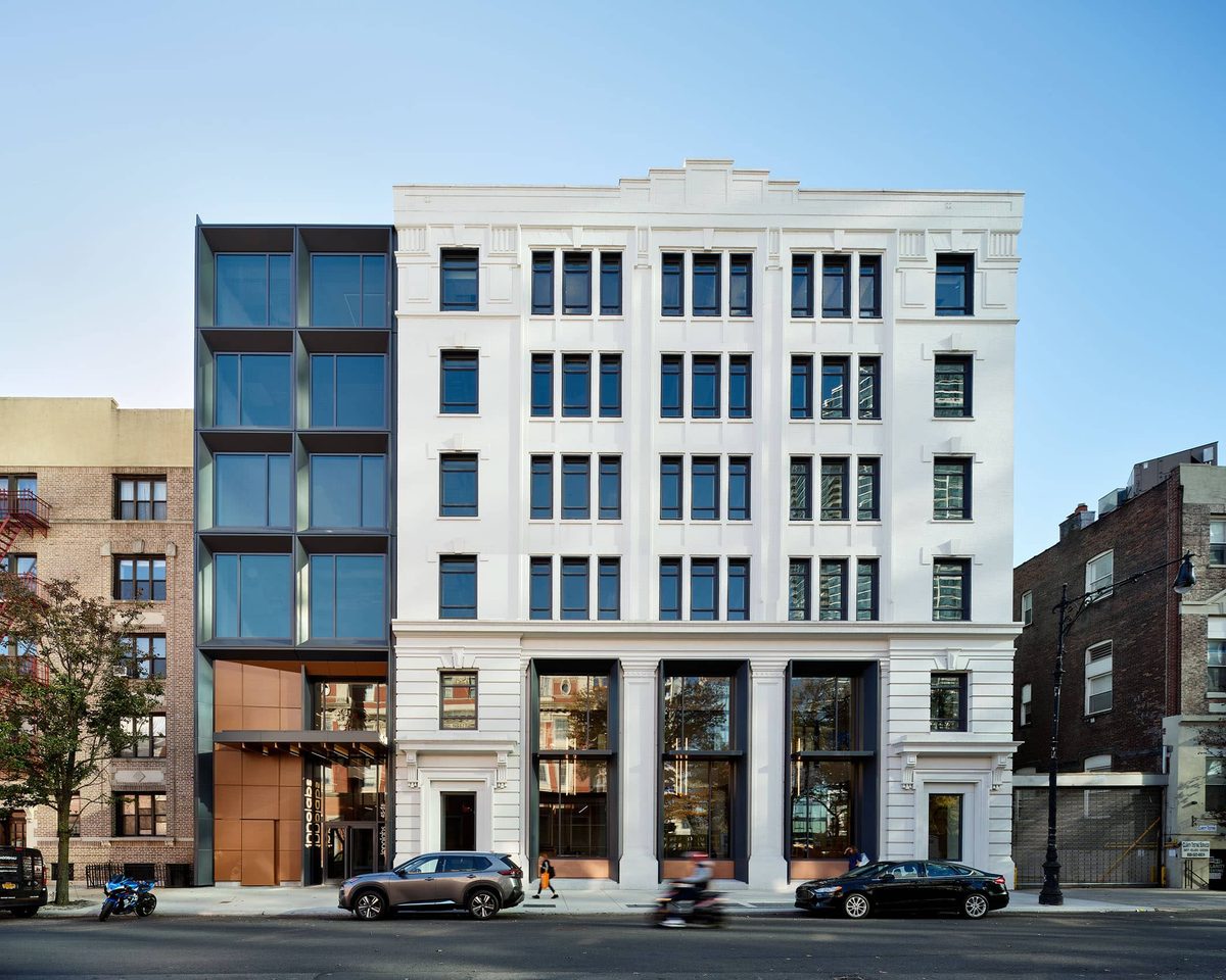 Street‑level exterior of Innolabs in Long Island City, showing the white classical façade and adjacent modern glass addition with the building entrance signage visible.