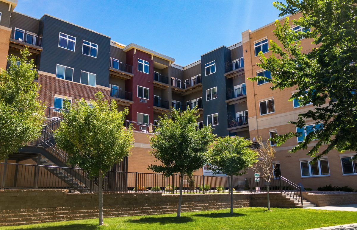 An apartment-community exterior illustrates the multifamily asset class represented by Villas del Tesoro and 46 Eleven Apartments, the 308-unit Dallas portfolio sold through a Chapter 11 auction by Marcus & Millichap.
