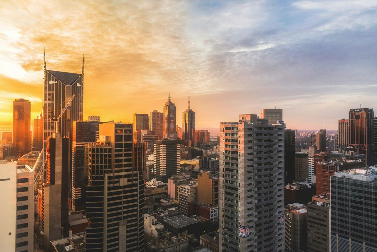 High‑rise commercial and residential towers at sunrise representing the Australian real‑estate assets held in Qualitas’ QDCI fund, which is the focus of the firm’s inaugural sustainable subscription line tying fund-level capital to qualifying green and social loan deployments.