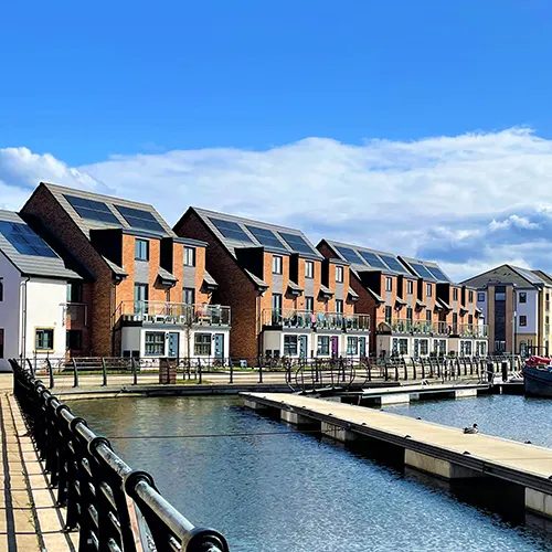 Waterfront residential homes illustrate the type of modern housing in Hearthstone Investments' UK portfolio, which Sentinel Real Estate acquired to expand its affordable rental platform.