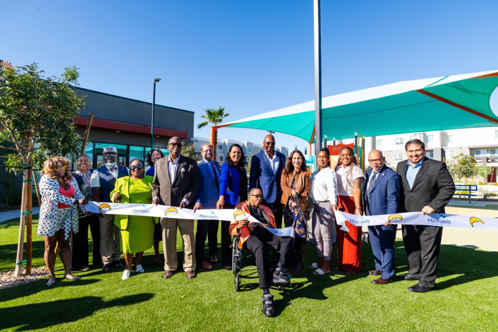 Southern Nevada Regional Housing Authority and The Michaels Organization representatives and community partners cut the ribbon at Gholson Landing, marking the opening of the 121-unit affordable community in Las Vegas.